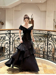 Vestido formal largo de satén negro con hombros descubiertos y capas
