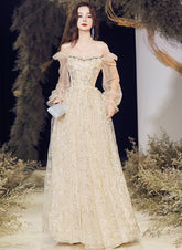 Vestido de noche largo de tul color champán con corte A y escote en V.