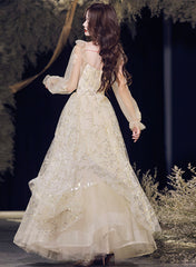 Vestido de noche largo de tul color champán con corte A y escote en V.
