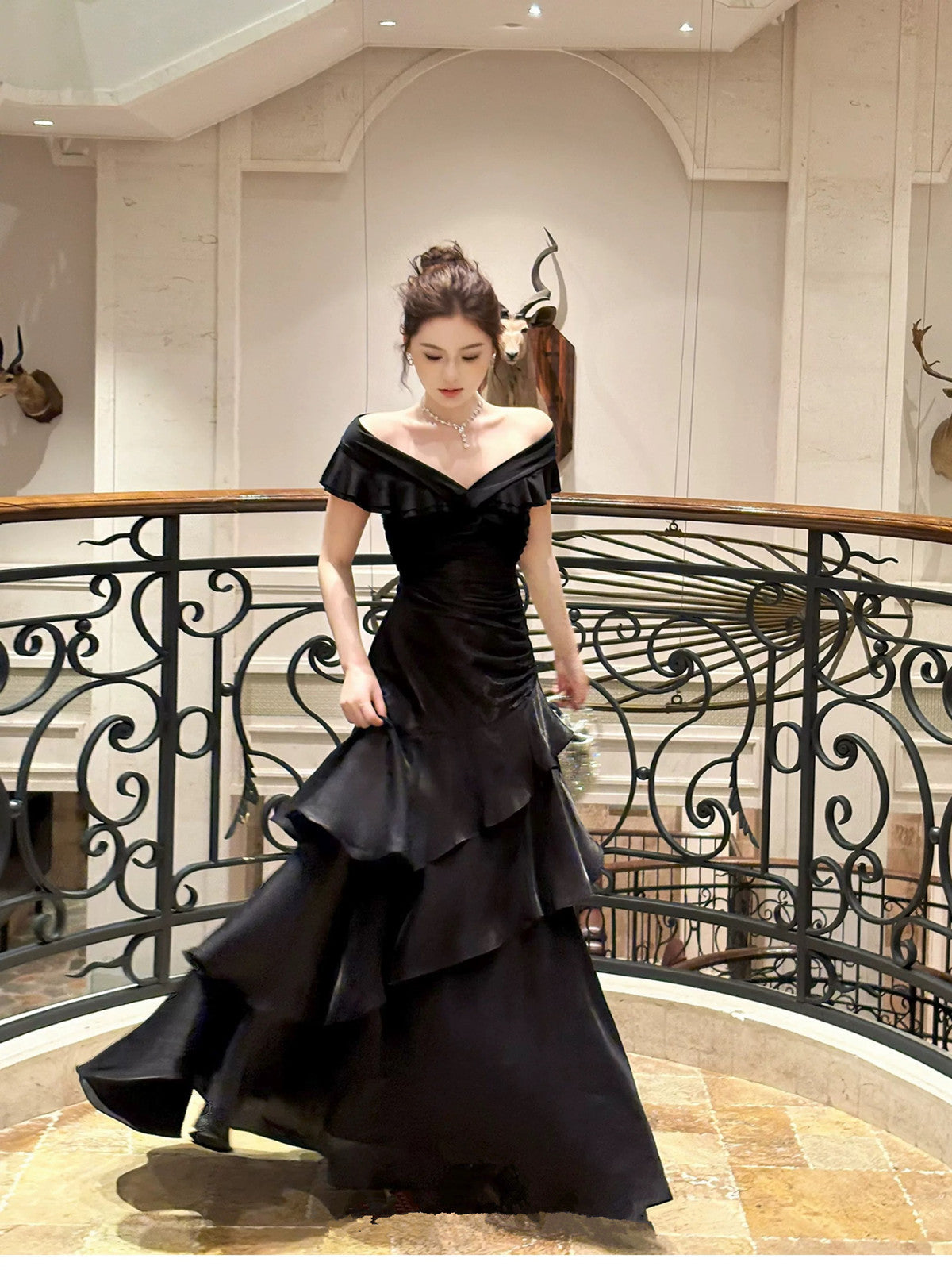 Vestido formal largo de satén negro con hombros descubiertos y capas 