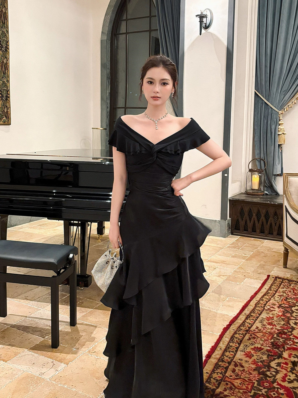 Vestido formal largo de satén negro con hombros descubiertos y capas 