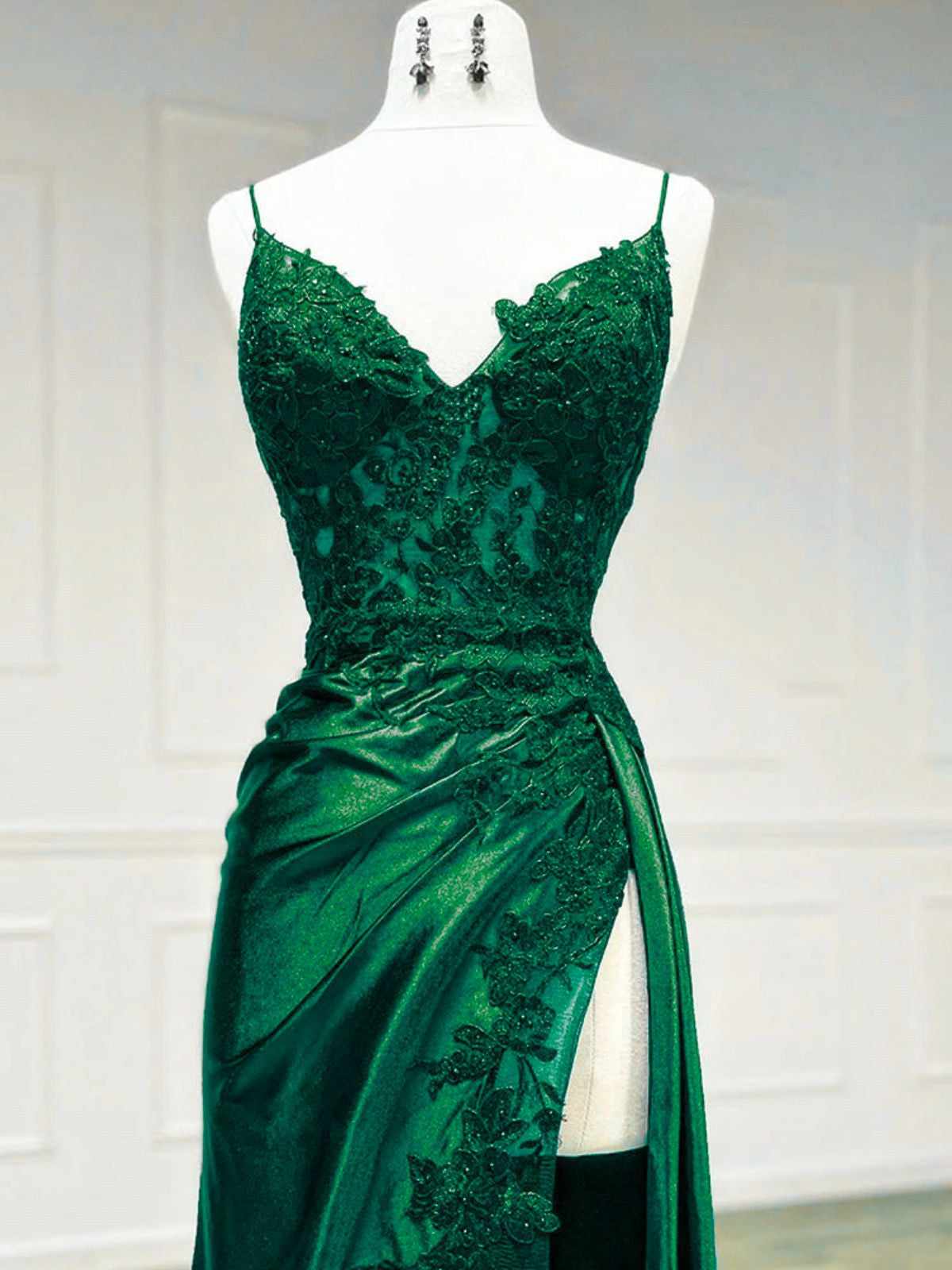 Vestido de noche largo de satén verde con tirantes de encaje y escote halter. 